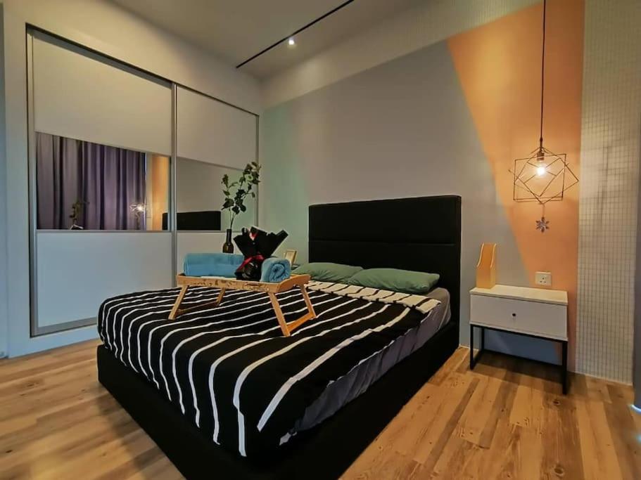 a bedroom with a large bed with a table on it at Mupify Homestay Gala City Gala Residences A4 in Kuching