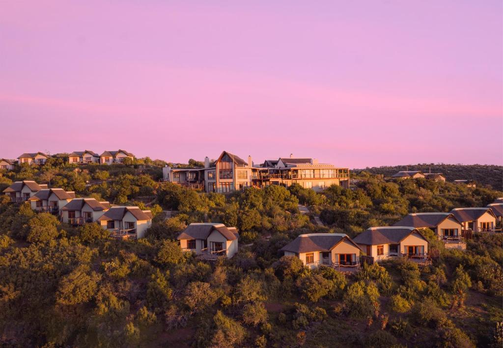 a row of houses on a hill at sunset at Kuzuko Lodge in Addo