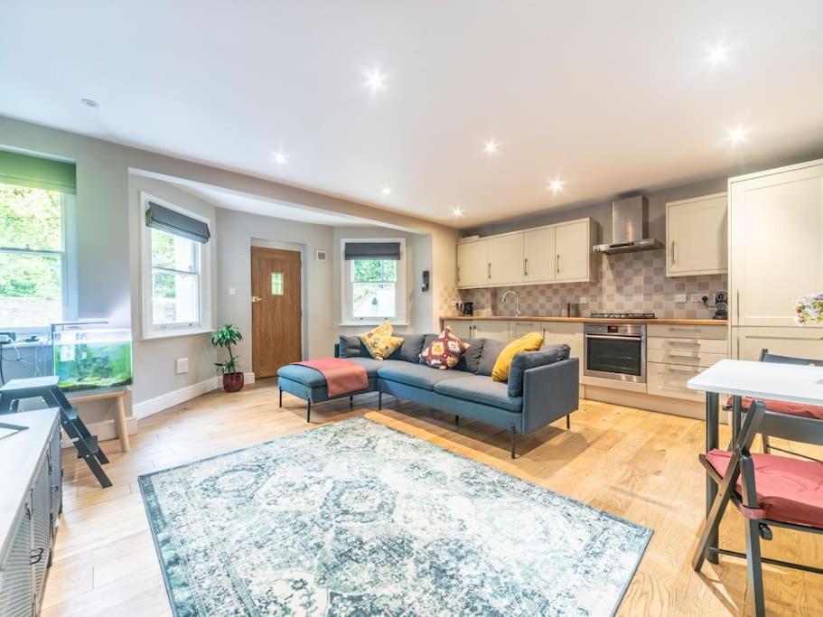 a living room with a couch and a kitchen at Surbiton Garden Flat in Surbiton