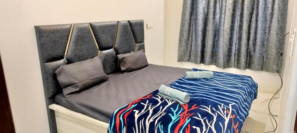 małe łóżko w pokoju z prześcieradłem w obiekcie Pleasant Stay B&B w mieście Amritsar