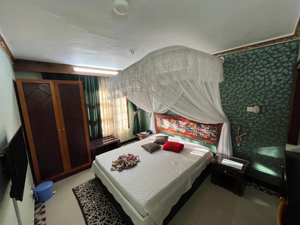 ein Schlafzimmer mit einem großen Bett mit Baldachin in der Unterkunft Dodoma Rock Hotel Ltd in Dodoma