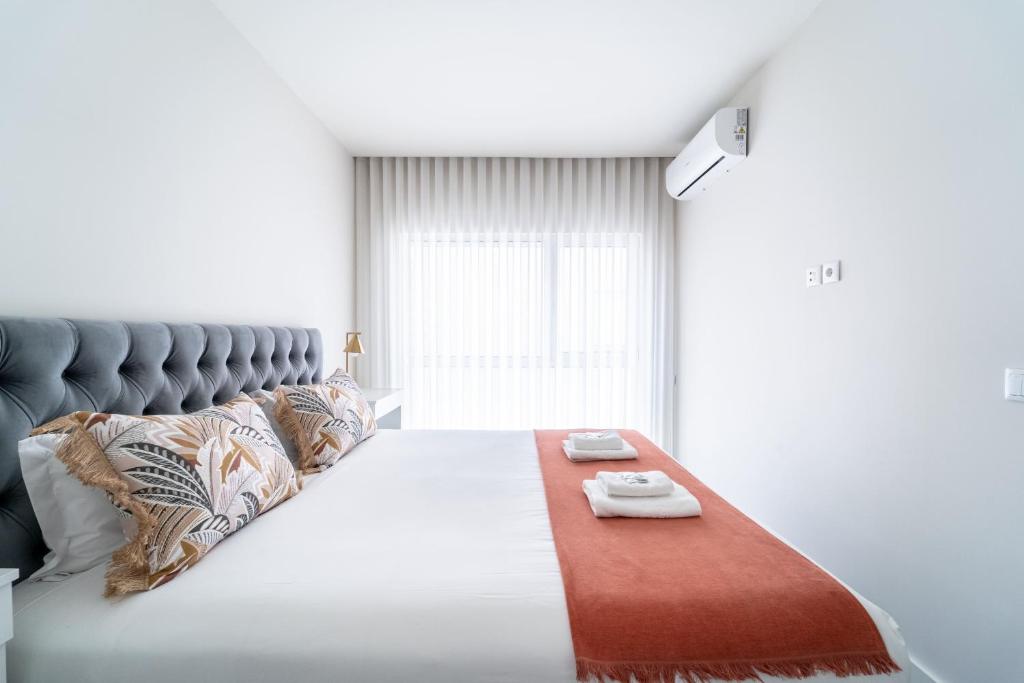 a bedroom with a large bed with a red blanket on it at T1 Urban Charm Central City Escape in Braga