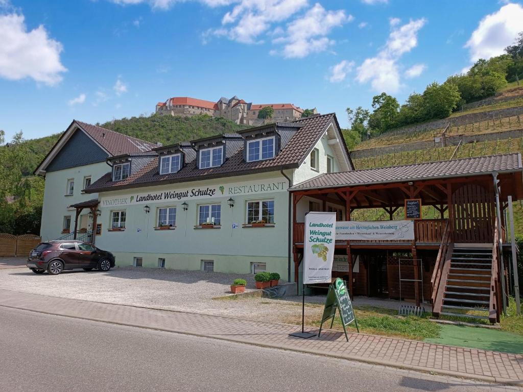 un edificio con un coche aparcado delante de él en Landhotel Weingut Schulze en Freyburg