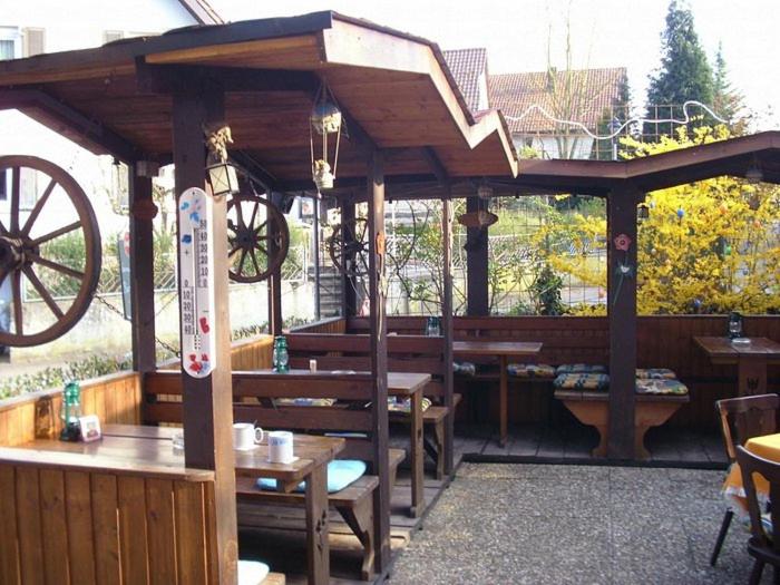 a wooden pavilion with tables and benches and a wheel at abmelden das unterkunft in Bad Rappenau