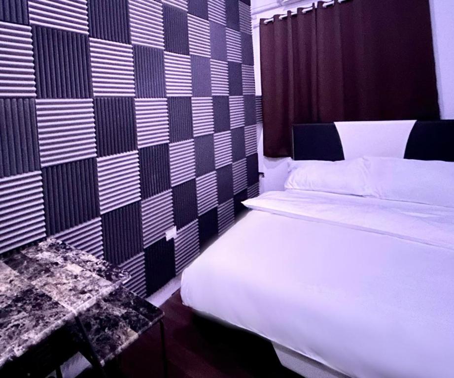a bedroom with a bed and a black and white wall at Private room with AC and fan at EKG House Rental in Manila