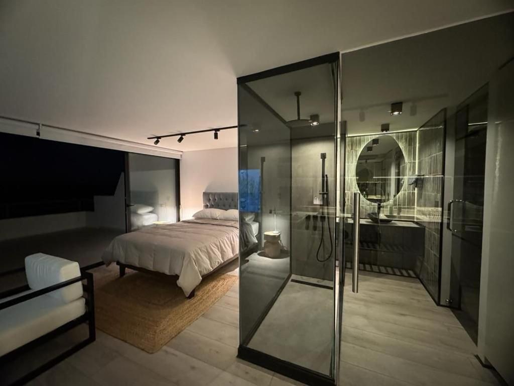 - une chambre avec un lit et un mur en verre dans l'établissement Moderno Depto Estudio frente a Playa Amarilla, à Concón