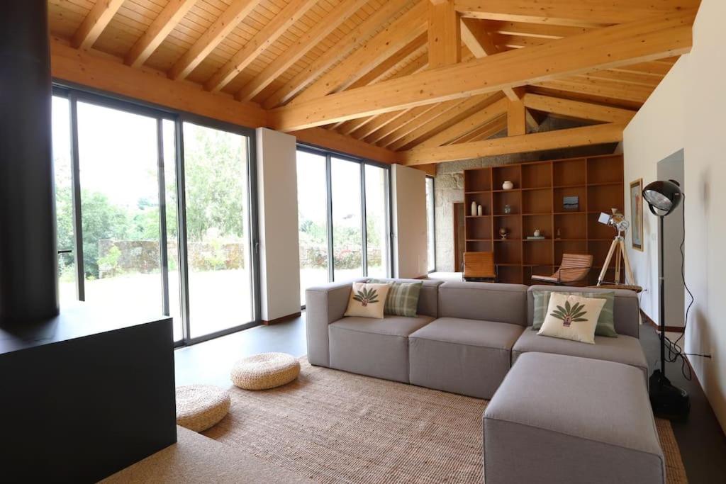 a living room with a couch and some windows at Quinta de Travanca - Casa do Páteo, Baião, Douro in Baião