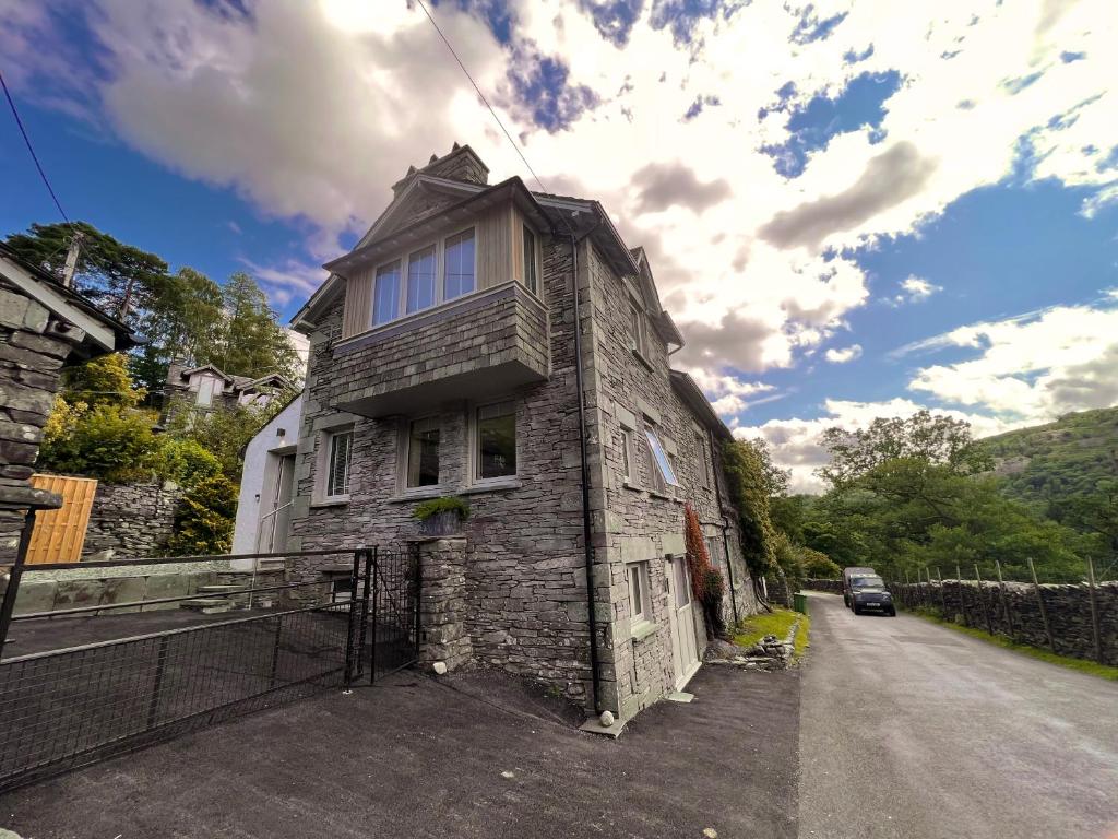 an old stone house on the side of a road at Langdale Boulders in Ambleside