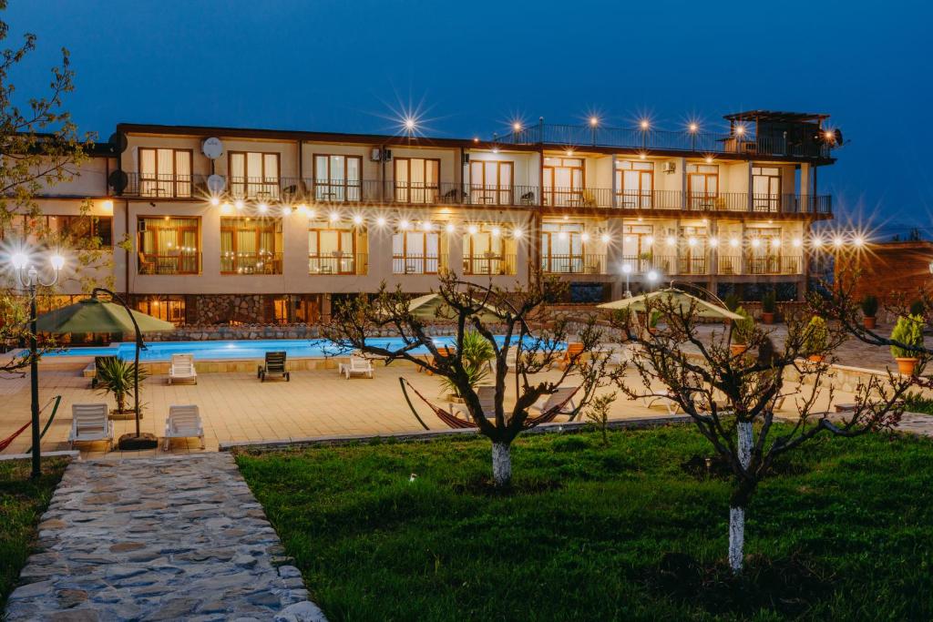 a large building with a pool in front of it at Hotel & Wine Cellar ARGE in Tʼelavi