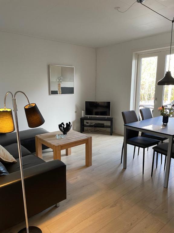 ein Wohnzimmer mit einem Sofa und einem Tisch in der Unterkunft Søhusets anneks1 in Viborg