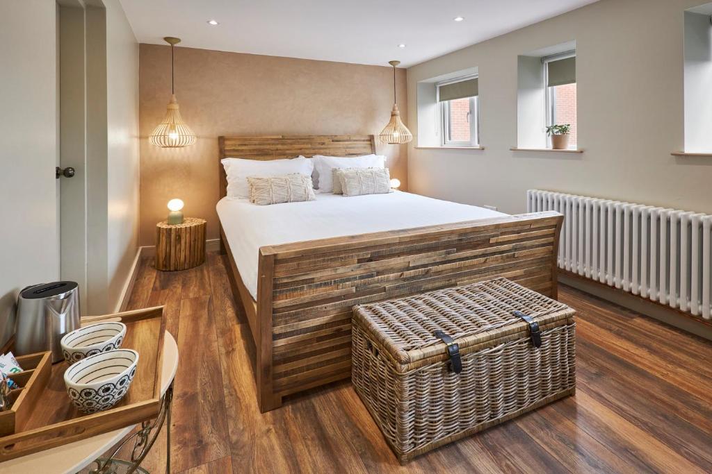 a bedroom with a large bed with a wicker trunk at The Believe Boutique (Believe Bar & Bedrooms) in Redcar