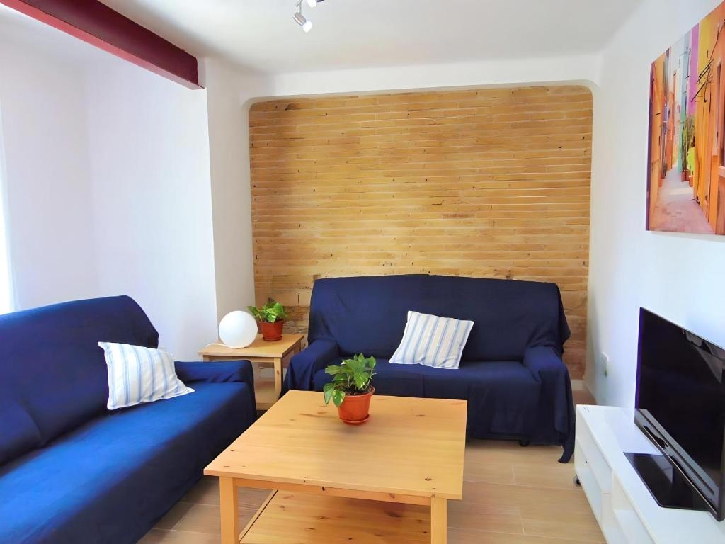 バレンシアにあるPrecioso piso en Cabanyal junto playa Las Arenasのリビングルーム(青いソファ、テーブル付)