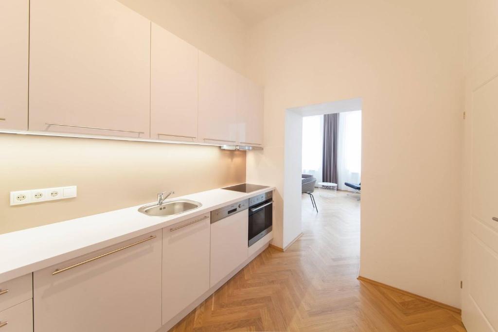 uma cozinha com armários brancos e um lavatório em KS70 Apartments em Viena