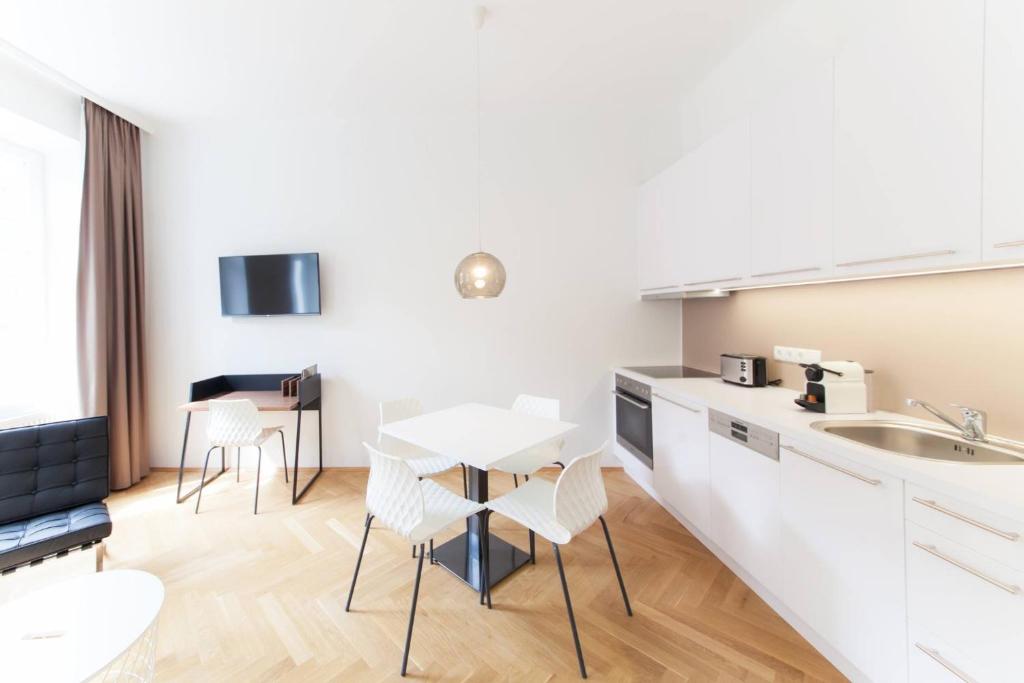 uma cozinha e sala de jantar com mesa e cadeiras em KS70 Apartments em Viena