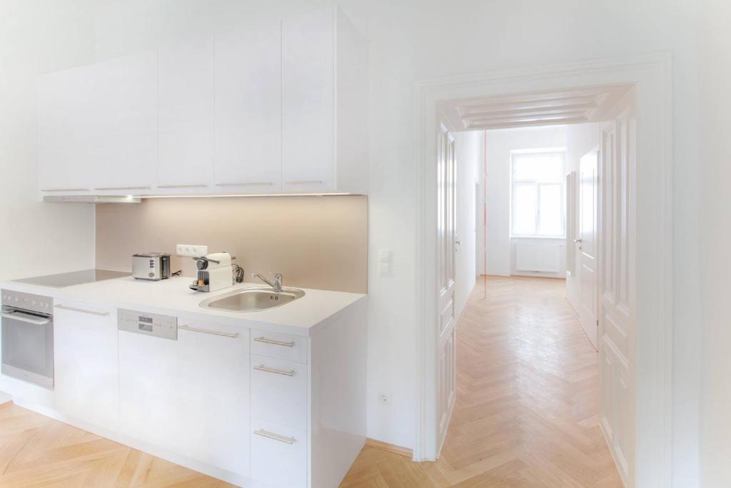 uma cozinha branca com um lavatório e um balcão em KS70 Apartments em Viena