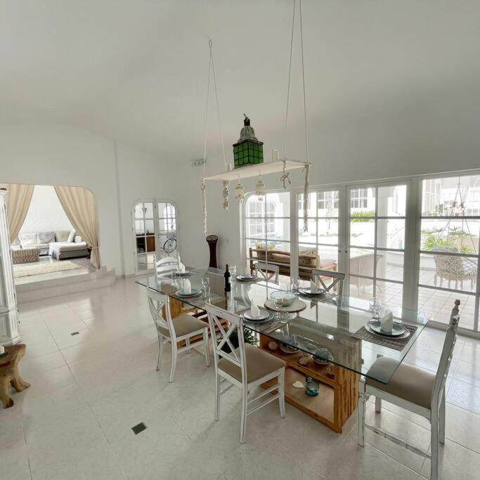 a dining room with a glass table and chairs at Große sonnendurchflutete Wohnung in Costa Calma
