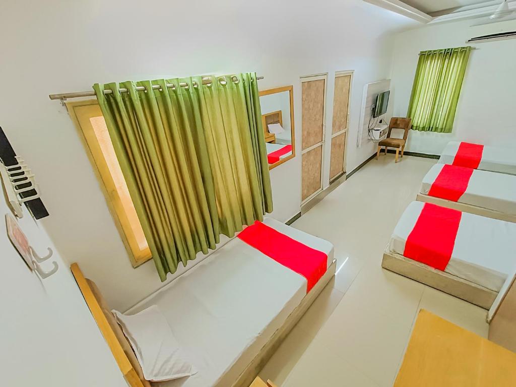 a bedroom with two beds and a window at Usha Residency in Bhuj