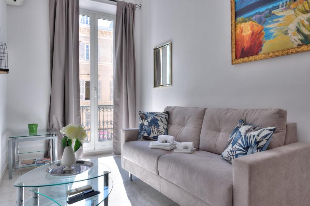 un salon avec un canapé et une table en verre dans l'établissement LE FELIX au cœur du centre-ville, emplacement idéal pour loisirs ou congrès, à Cannes