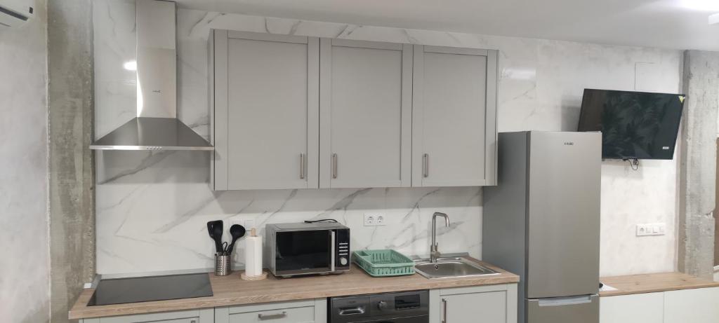 a kitchen with white cabinets and a microwave at Apartamento Centro B in San Sebastián de los Reyes