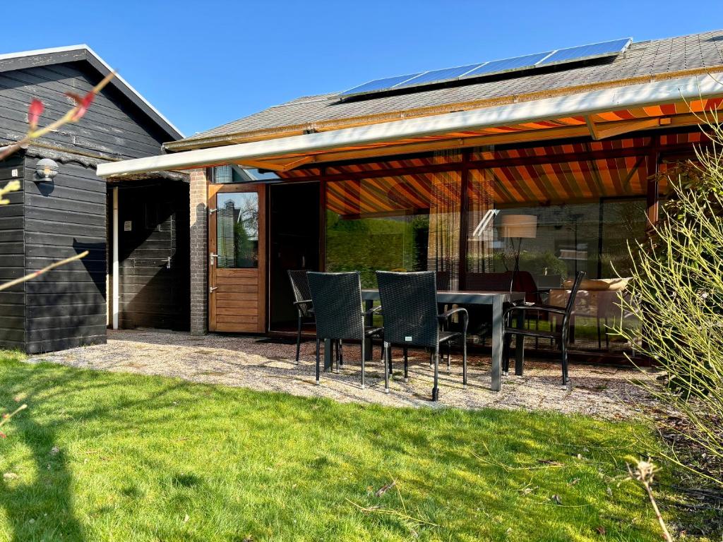 a patio with a table and chairs on it at Boerenslag 15 in Sint Maartensvlotbrug