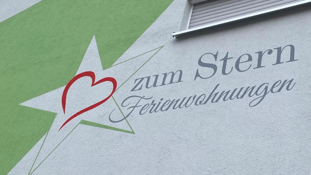 a sign on a building with a heart and a star at Ferienwohnungen zum Stern in Bühlertann