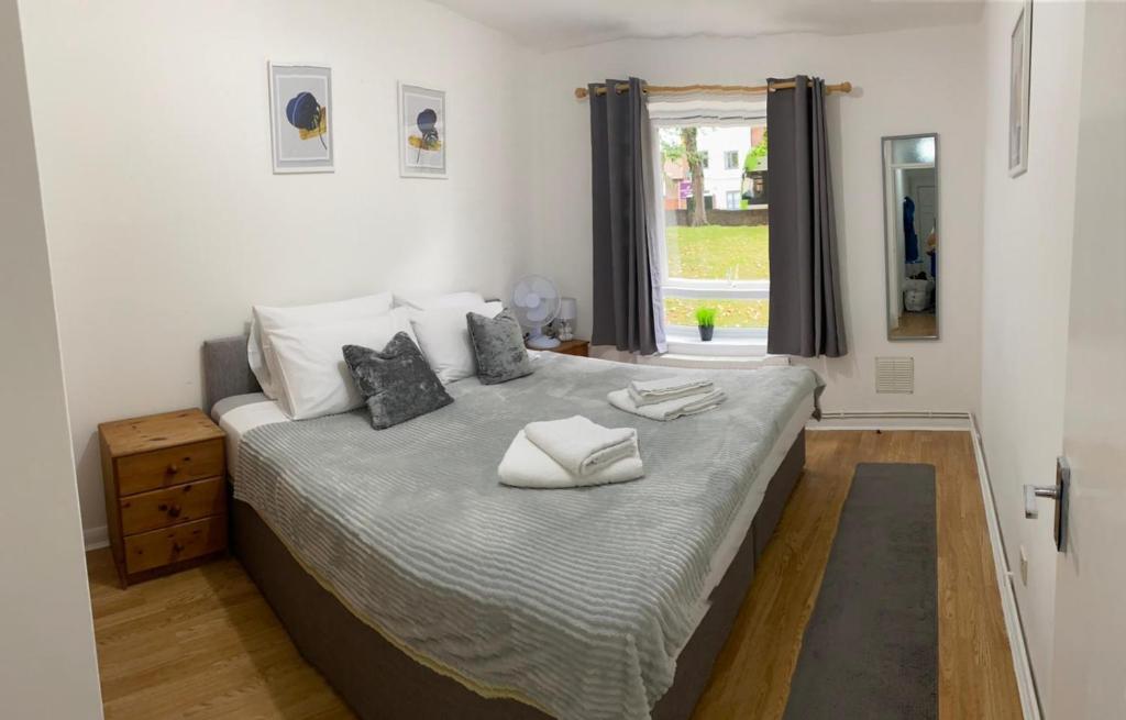 a bedroom with a bed with two pillows on it at Cozy 1 Bed apartment, near East Croydon,15 minutes from Gatwick 13 minutes to London Bridge free parking , WIFI in South Norwood