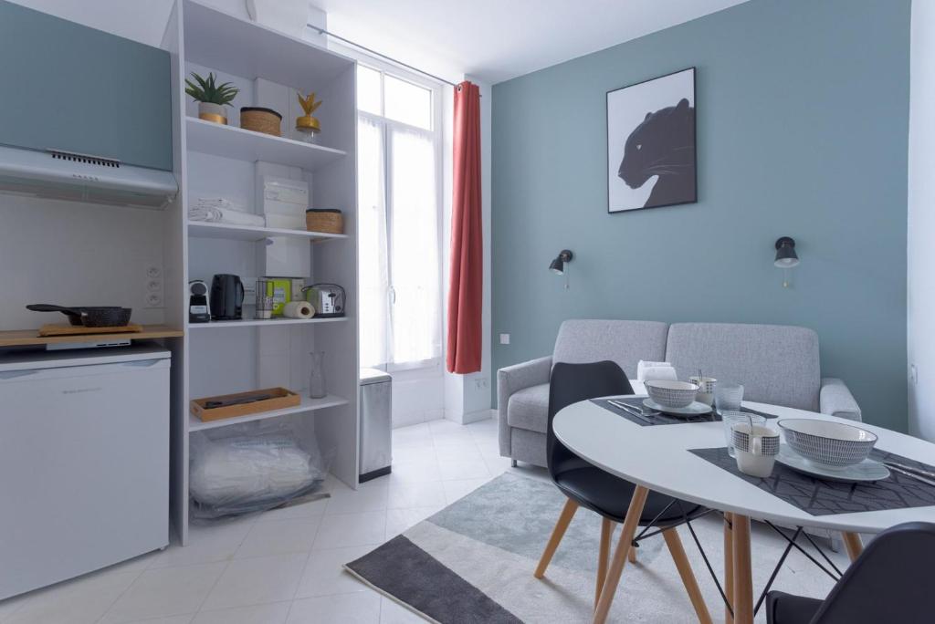 une cuisine et un salon avec une table et des chaises dans l'établissement LE MIMONT studio central et calme, séjours en couple ou congrès, à Cannes