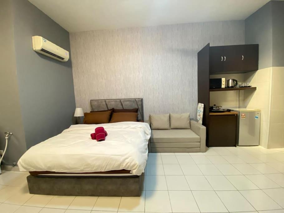 1 dormitorio con 1 cama con sombrero rojo en 5min to Sunway Lagoon#Subang SS15 Cozy Studio#3pax, en Subang Jaya