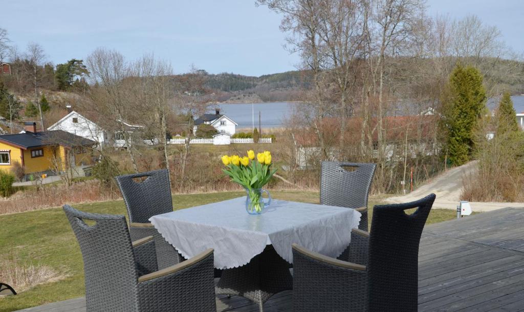 Nice cottage outside Munkedal with sea view في مونكيدال: طاولة عليها إناء من الزهور الصفراء