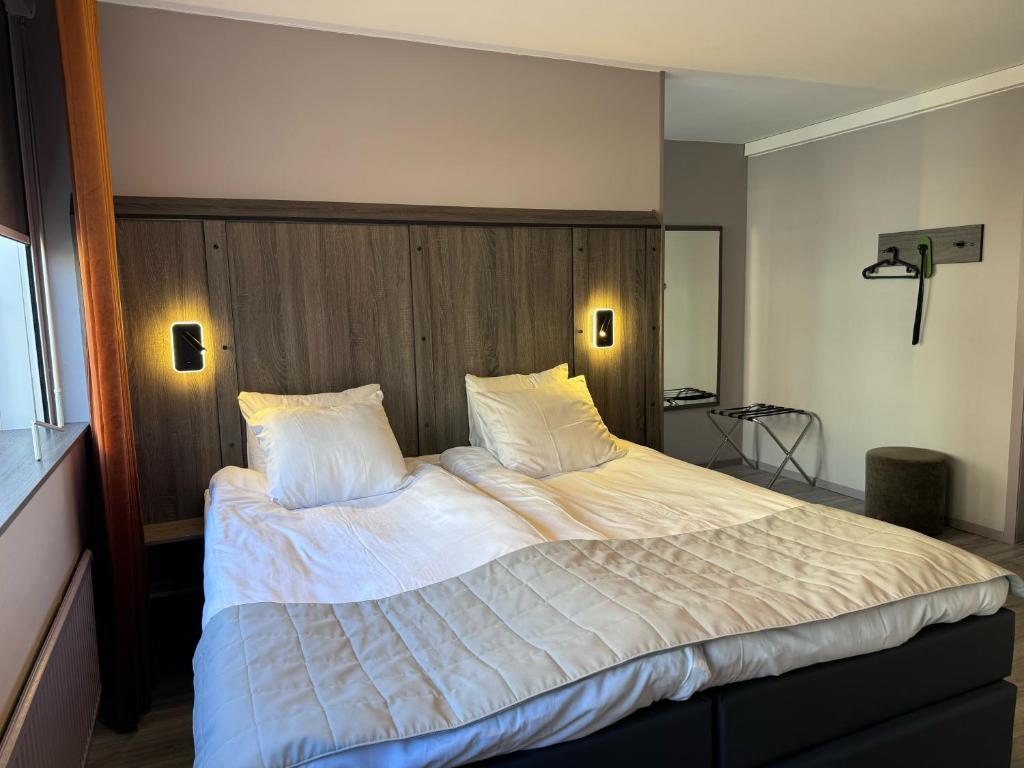 City Central Hotel Örebro by First Hotels في أوريبرو: غرفة نوم بسرير كبير عليها شراشف ووسائد بيضاء