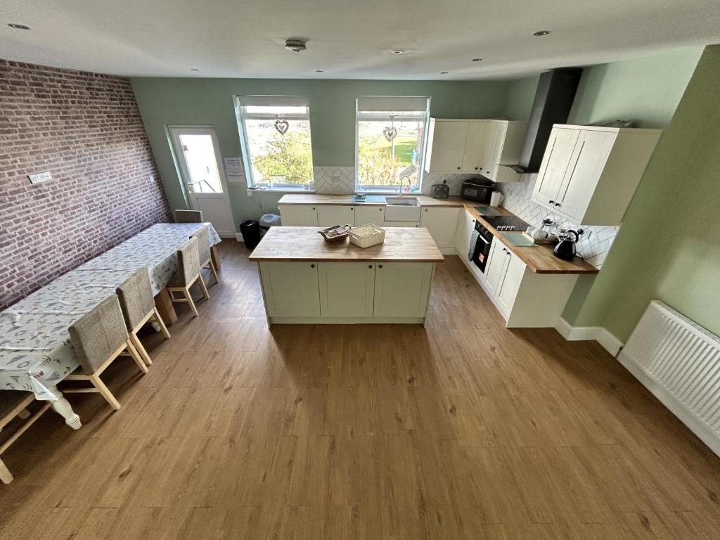 una cocina con mesas y sillas en una habitación en Sandy Lodge en Hornsea