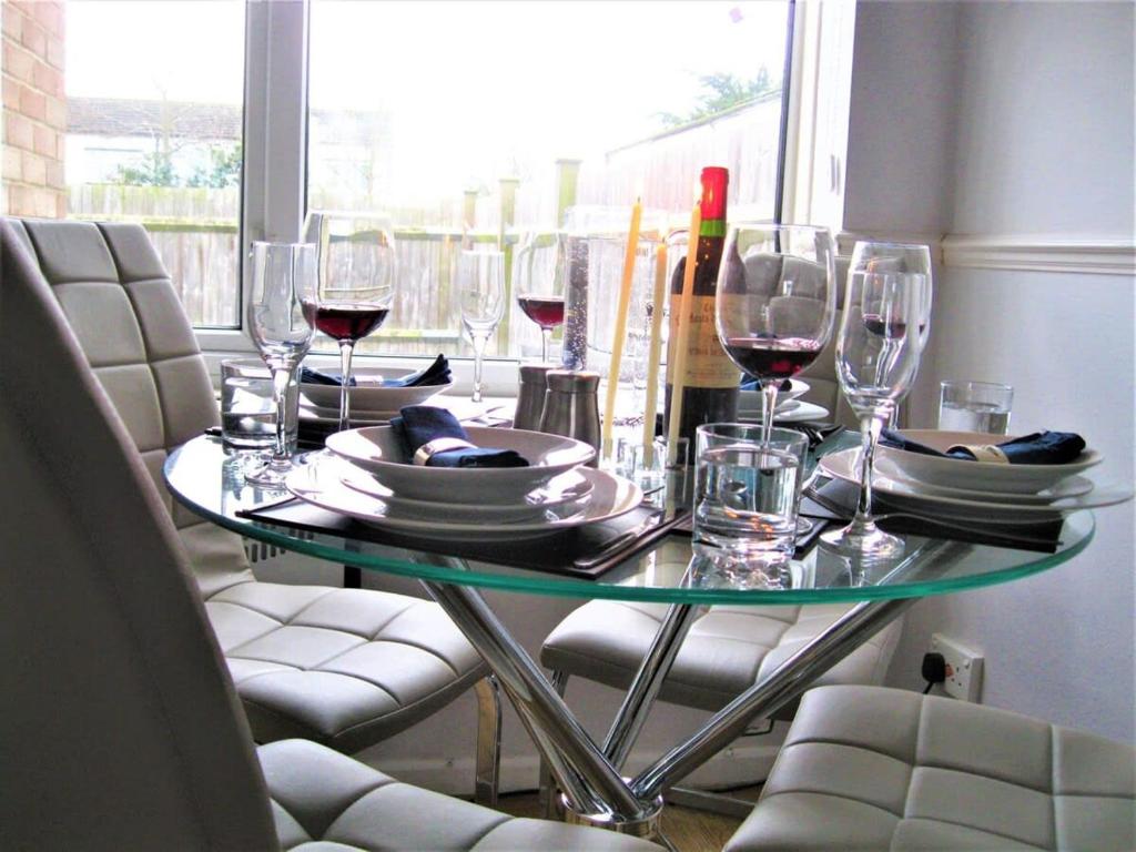 a table with glasses and plates and wine bottles at Honest Airport University House 1 with FREE PARKING and FAST WIFI in Southampton