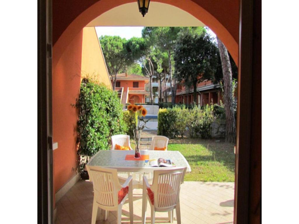 een witte tafel en stoelen op een patio bij Charming apartment with garden - Beahost in Bibione