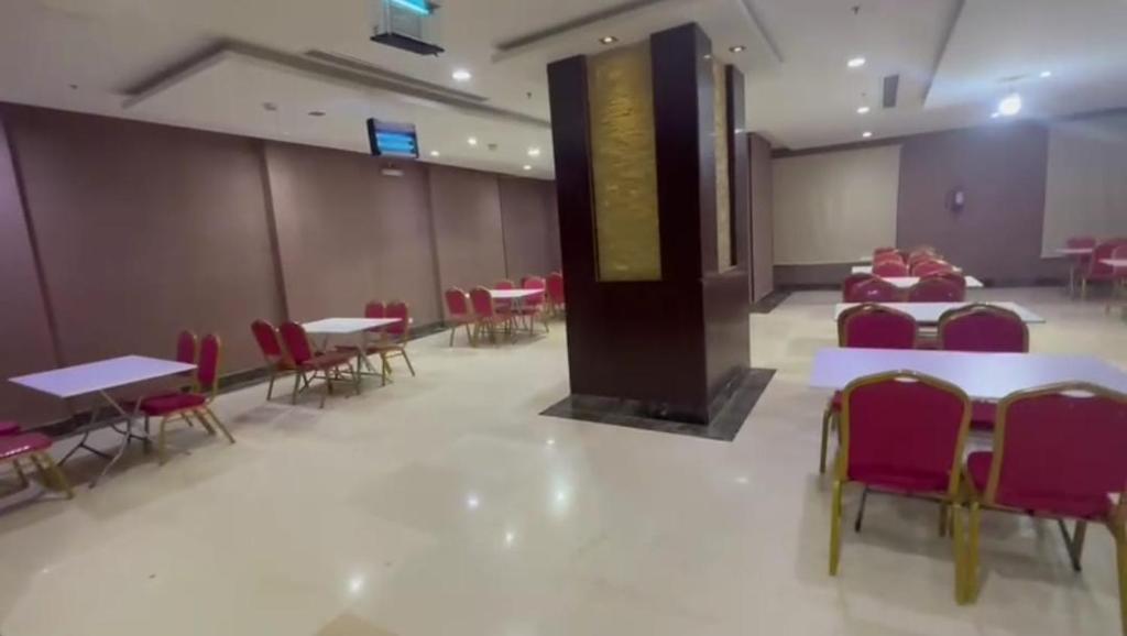 a conference room with tables and chairs and a podium at Arfalon Hotel and Tourism in Makkah