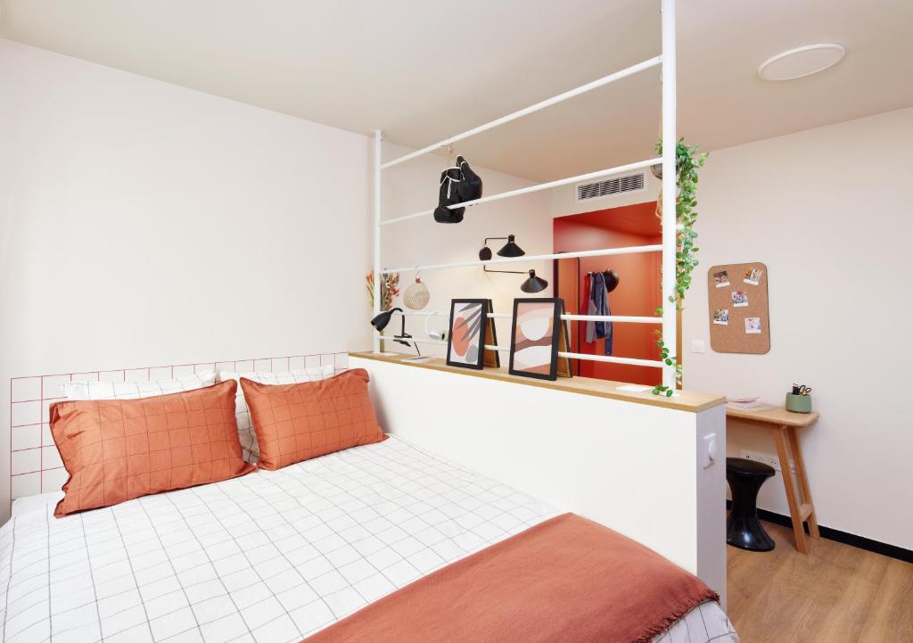 a bedroom with a bed with orange pillows at Hife Paris Issy in Issy-les-Moulineaux
