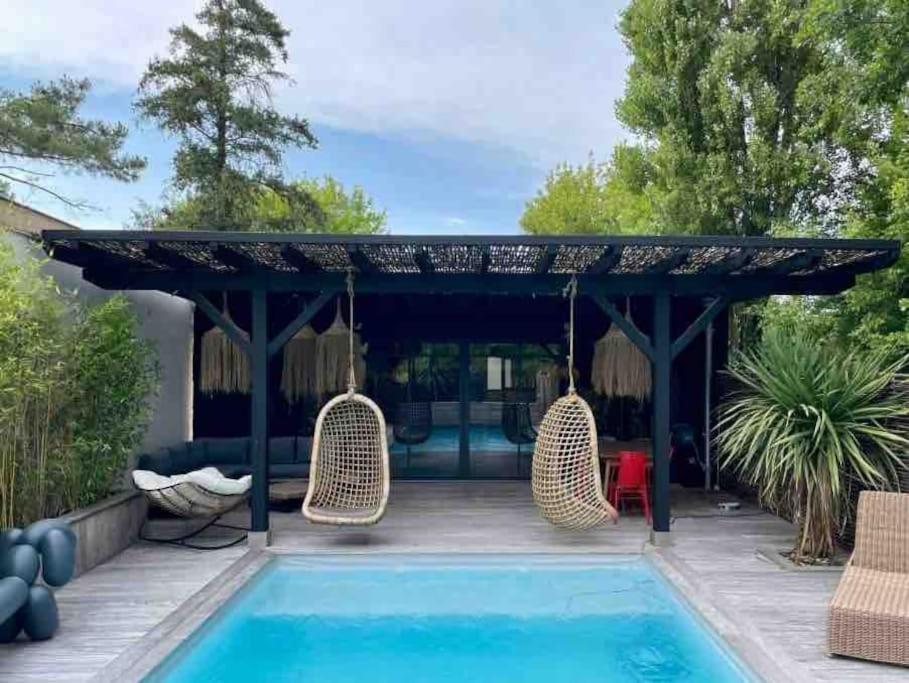 un patio avec des chaises et une piscine dans l'établissement Villa Le Patio Bleu au calme, piscine chauffée, centre ville, à Arès