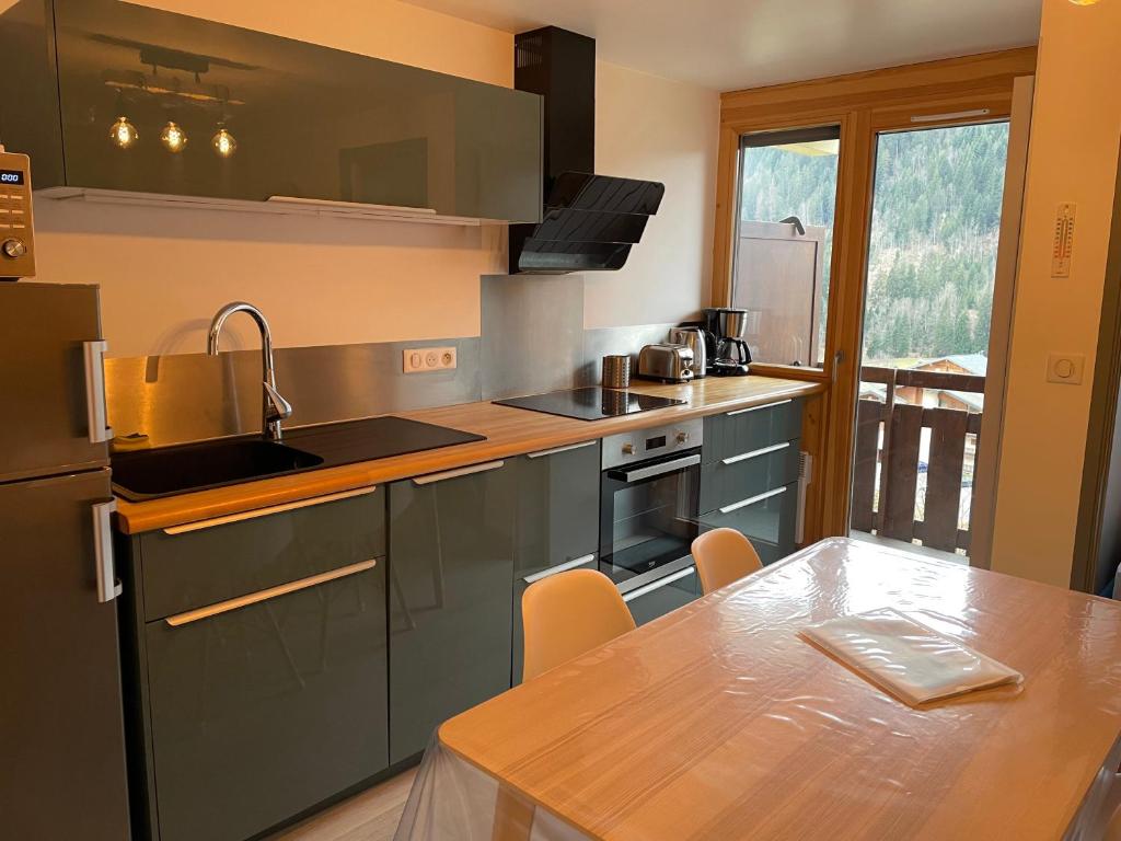a kitchen with a table and a counter top at Charmant appartement 2 pièces - 4 personnes in Châtel