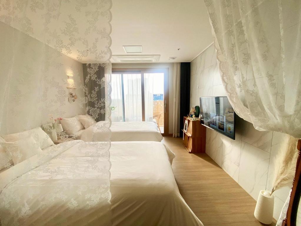 Cette chambre comprend 2 lits et une fenêtre. dans l'établissement Morning Madrid, à Jeju