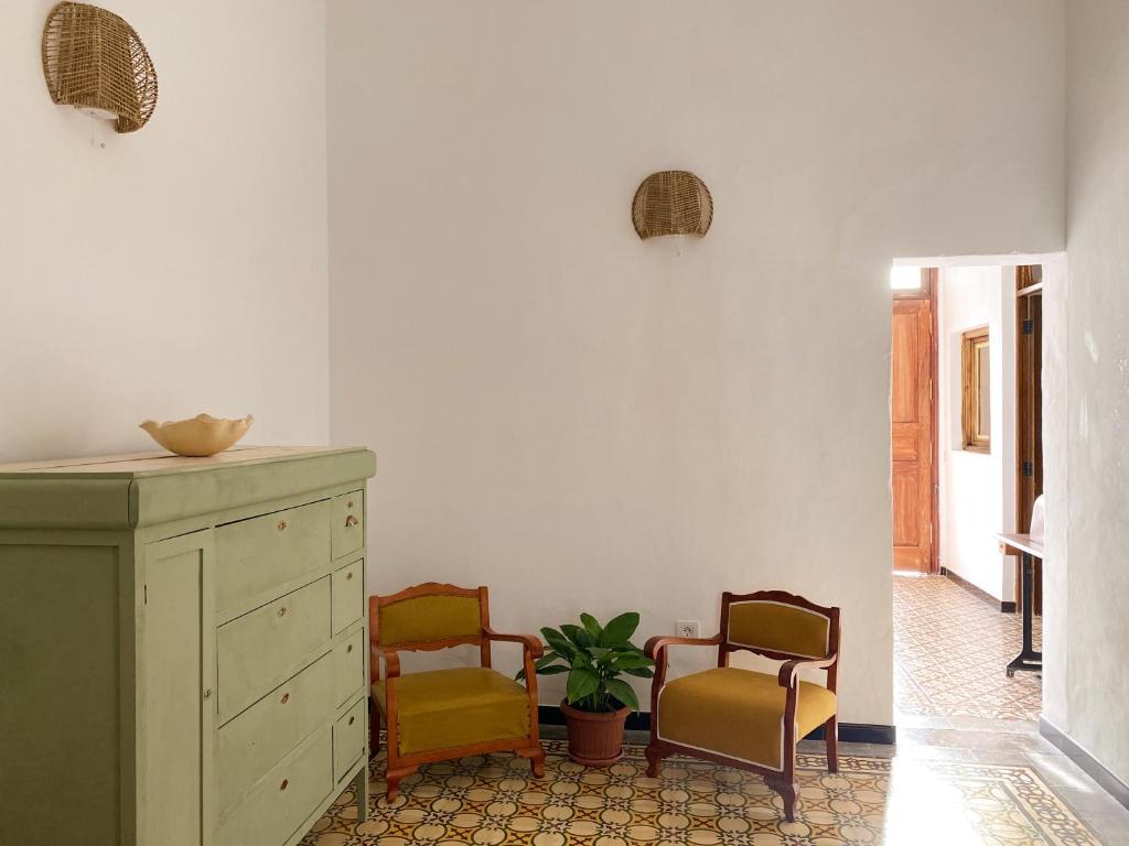 een woonkamer met 2 stoelen en een dressoir bij Casa Álvaro in Fasnia