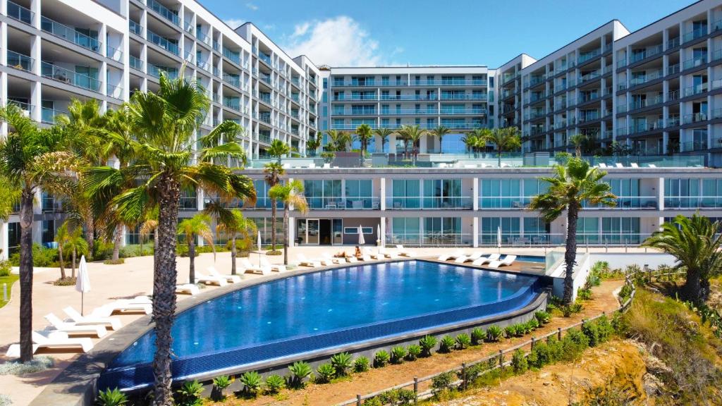een uitzicht op een resort met een zwembad en palmbomen bij Lexus Avenue by LovelyStay in Funchal