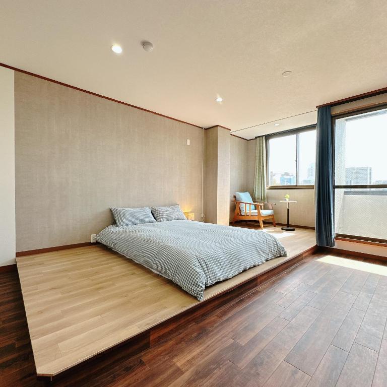 a bedroom with a bed on a wooden floor at 【三米通天閣】401-4FA難波商圈天王寺心斎橋10min in Osaka