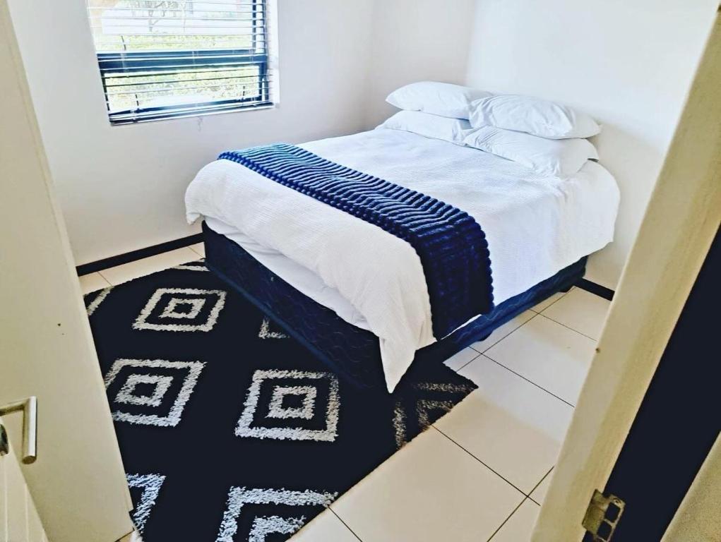 a bed in a room with a black and white rug at Luxurious Exclusive Home In A Golf Estate in Roodepoort
