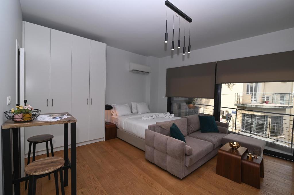 a bedroom with a bed and a couch and a table at Nueva Upscale by Neuvel in Athens