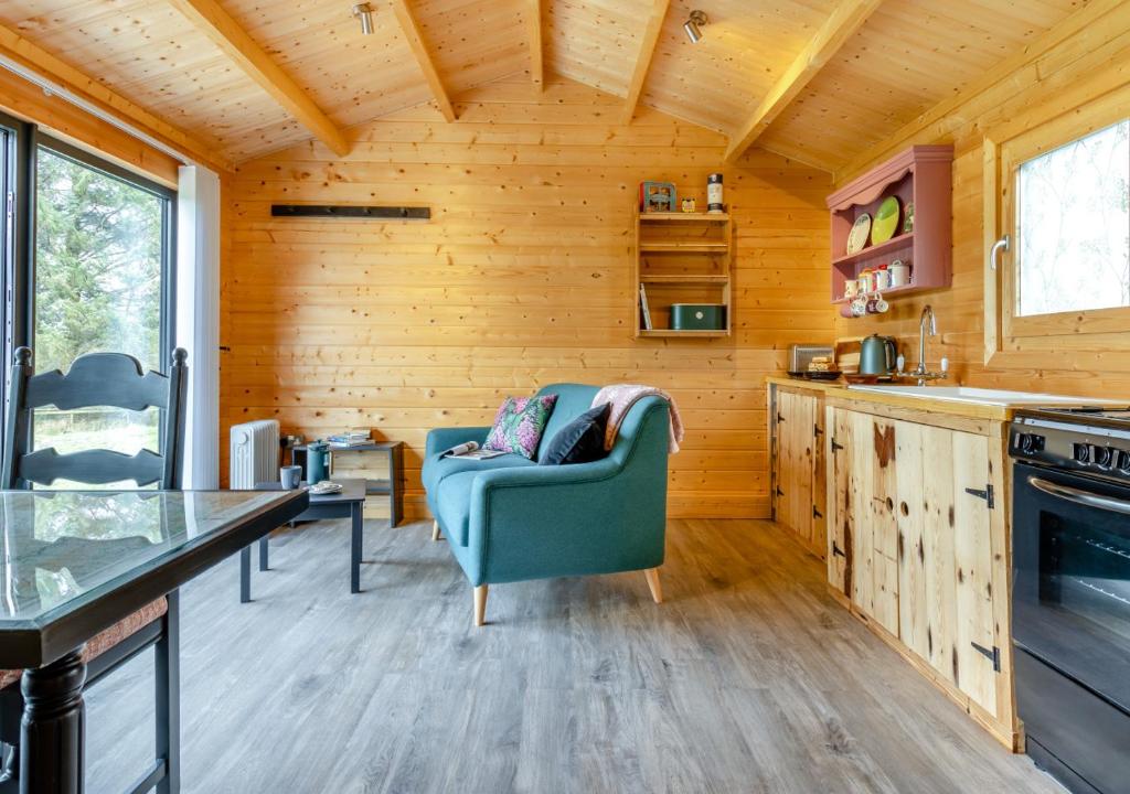 uma cozinha e sala de estar com um sofá e uma mesa em Foxglove Cabin em Devils Bridge