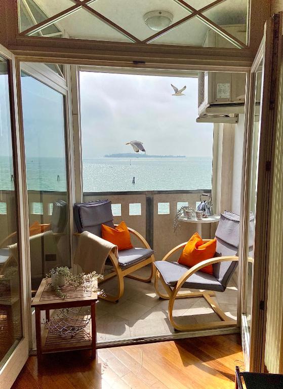 a room with chairs and a view of the ocean at Miami in Venice in Venice