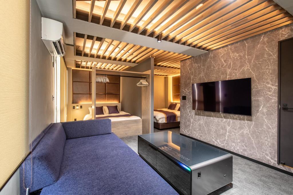 uma sala de estar com um sofá roxo e uma televisão em Nexus Gotanda em Tóquio