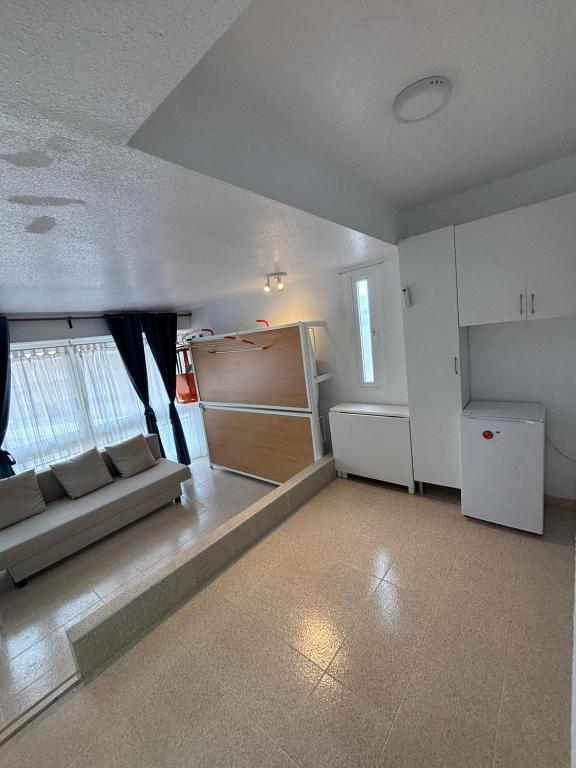 a living room with a couch and a refrigerator at ESTUDIO DOS PLAYAS LA MANGA in Murcia