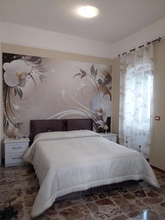 a bedroom with a large bed with flowers on the wall at SA' GRAVIN in Castellaneta
