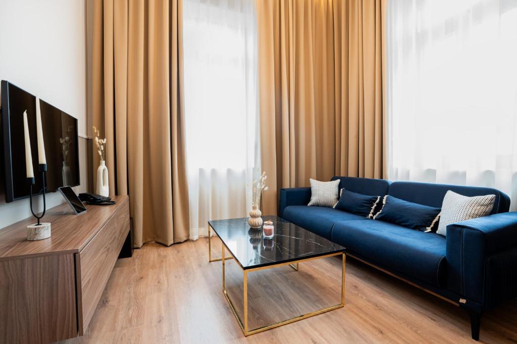 a living room with a blue couch and a tv at Oikia Classic House in Kavala