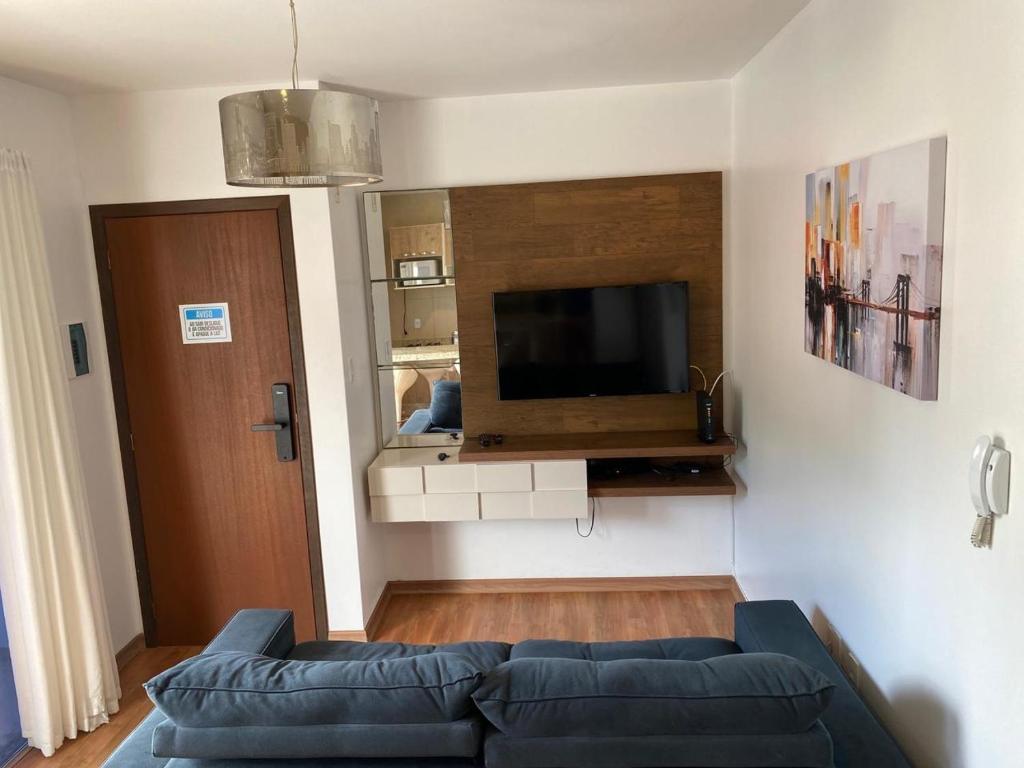 uma sala de estar com um sofá e uma televisão de ecrã plano em Apartamento Inteiro Completo 2 Quartos com AC em Blumenau SC à 10min Vila Germânica em Blumenau